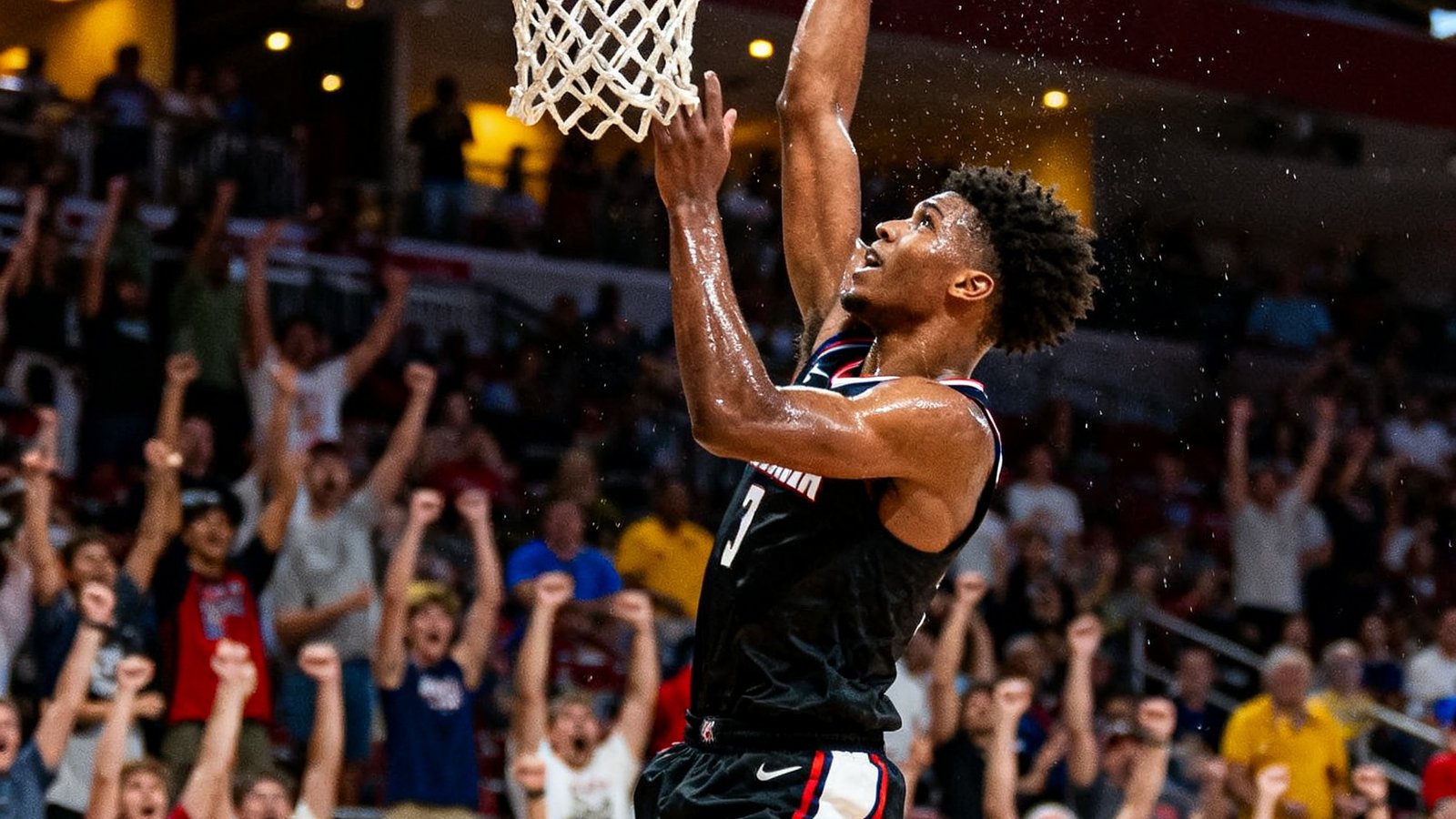 NBA夏季联赛中新秀球员在快攻中完成一记双手暴扣的精彩画面，场边观众纷纷起立欢呼